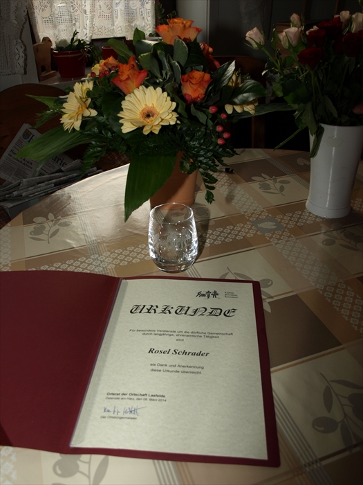 Blumenstrauß, Glas und Urkunde